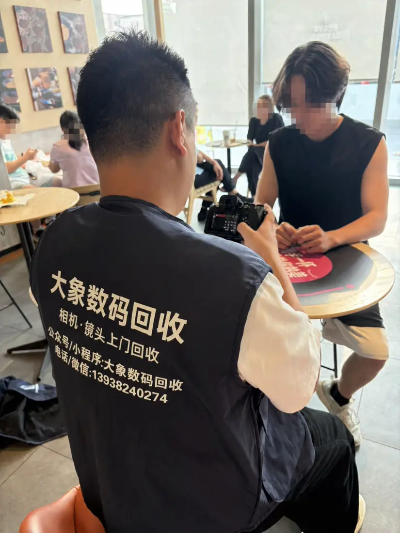 大象数码回收工作人员在咖啡店与用户当面检查相机