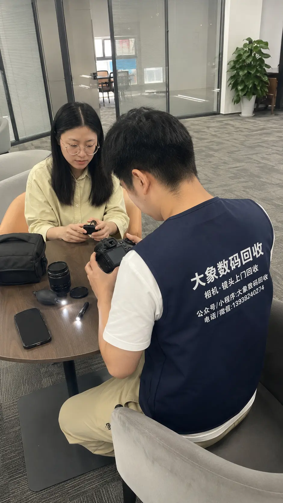 大象数码回收工作人员在办公场景当面检查相机